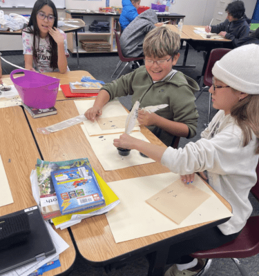 Students practicing the use of quill pens