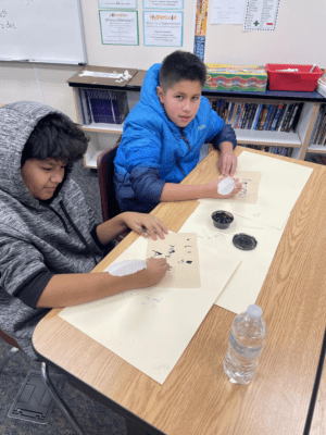 Students practicing the use of quill pens